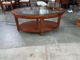 Elegant solid wood oval shaped coffee table with beveled glass top