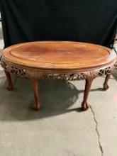 Vintage wood coffee table with ornate carvings, grape motif, & claw feet