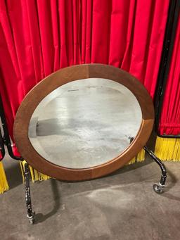 Small oval wood-framed hanging beveled mirror