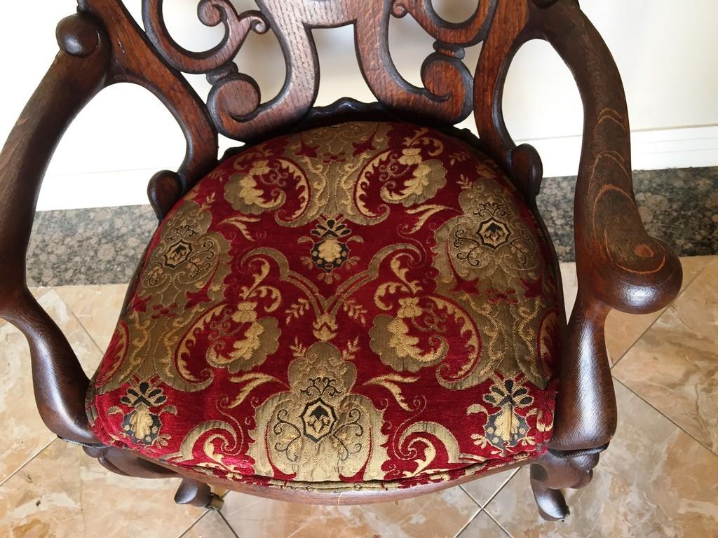 ANTIQUE AMERICAN OAK CHAIR WITH RED/GOLD PRINT ON CASTERS