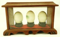 Lot 1711 - (3) Oriental painted eggs in small showcase