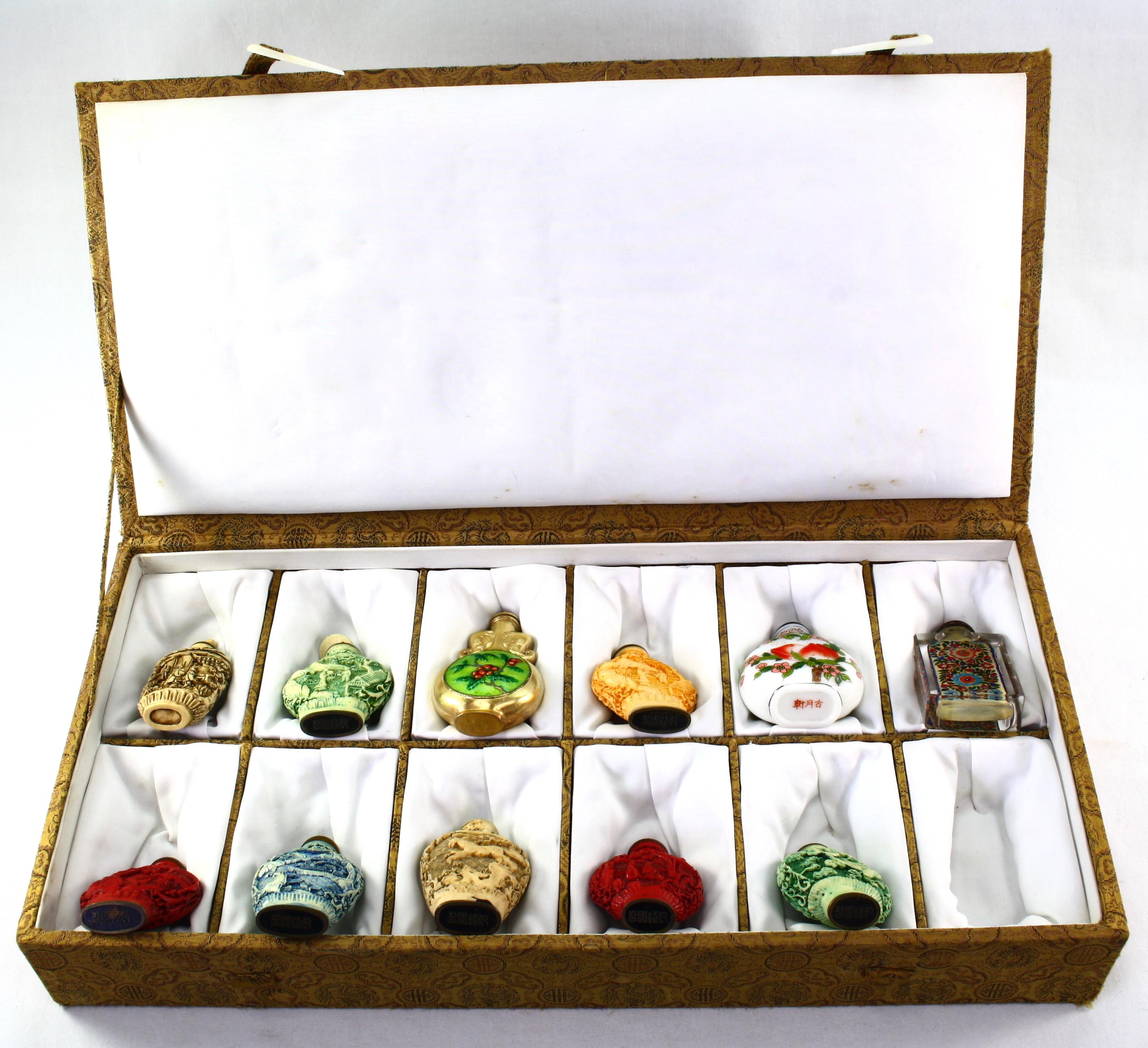 Collection of 11 Oriental snuff bottles in a plush hinged case