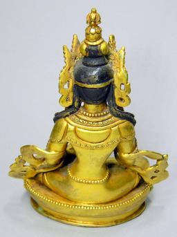 Tibetan Gilt Bronze Figure of Buddha Akshobhya Holding an Oil Lamp