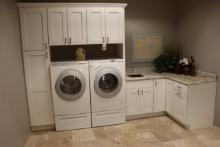 135" x 92" tall white "L" shaped laundry room cabinet with solid surface to