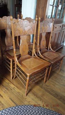 Four pressed oak chairs with wicker bottoms