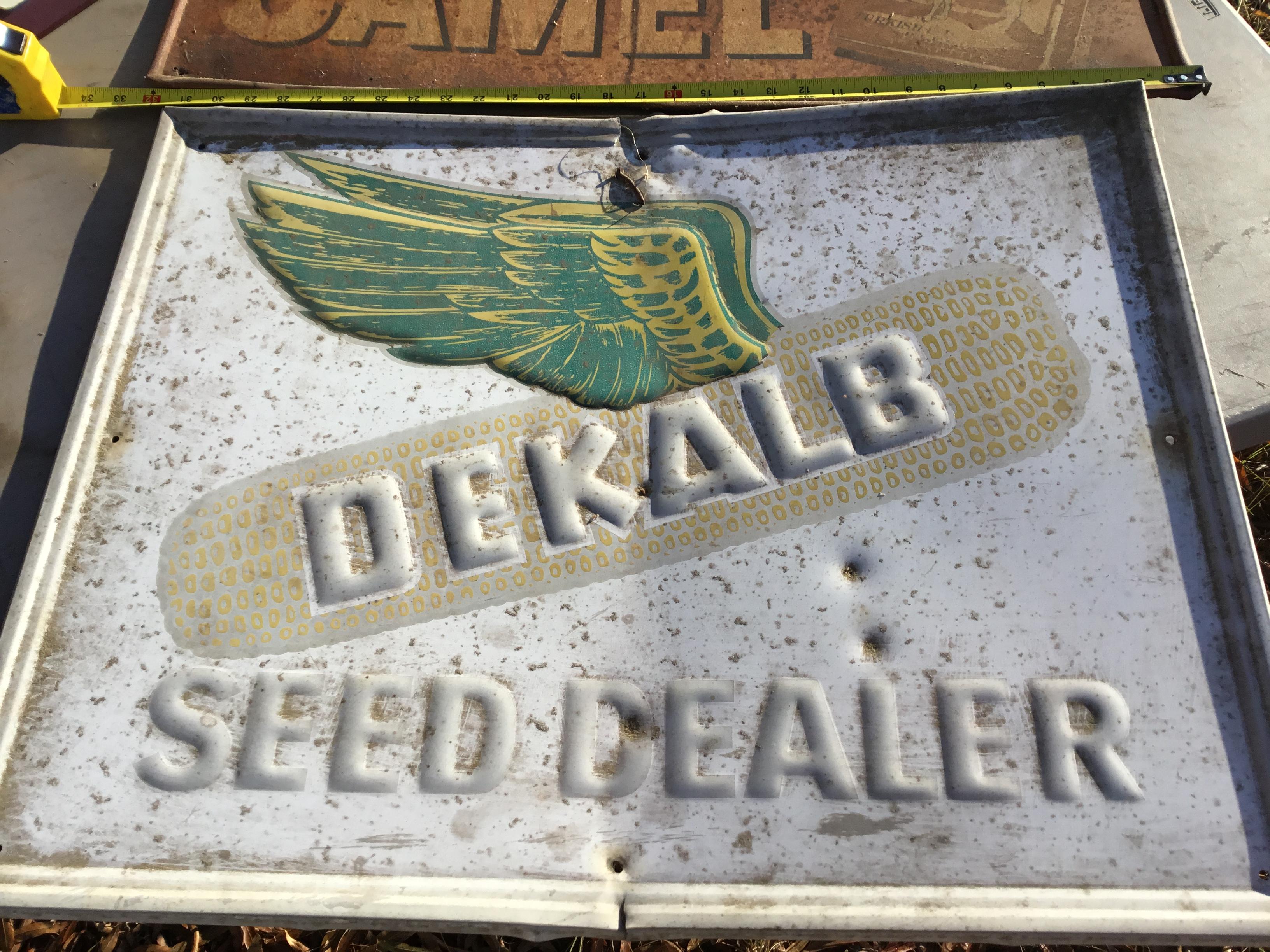 Group of 2 metal signs - Camel 12" x 32" (rusted), Dekalb Speed Dealer 23" x 29" (minor damage)