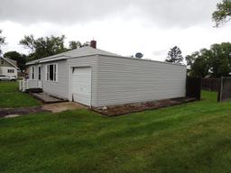 Lot 1: 406 4th St SE.  28x32 house with gray vinyl siding and attached 12x2