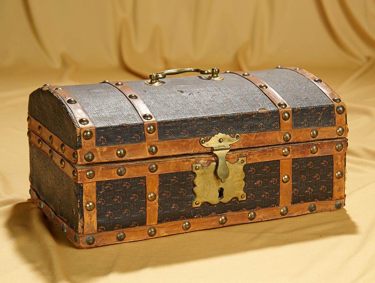 12" x 7" x 5" Early petite domed wooden trunk with cast brass key plate and handle. $400/600