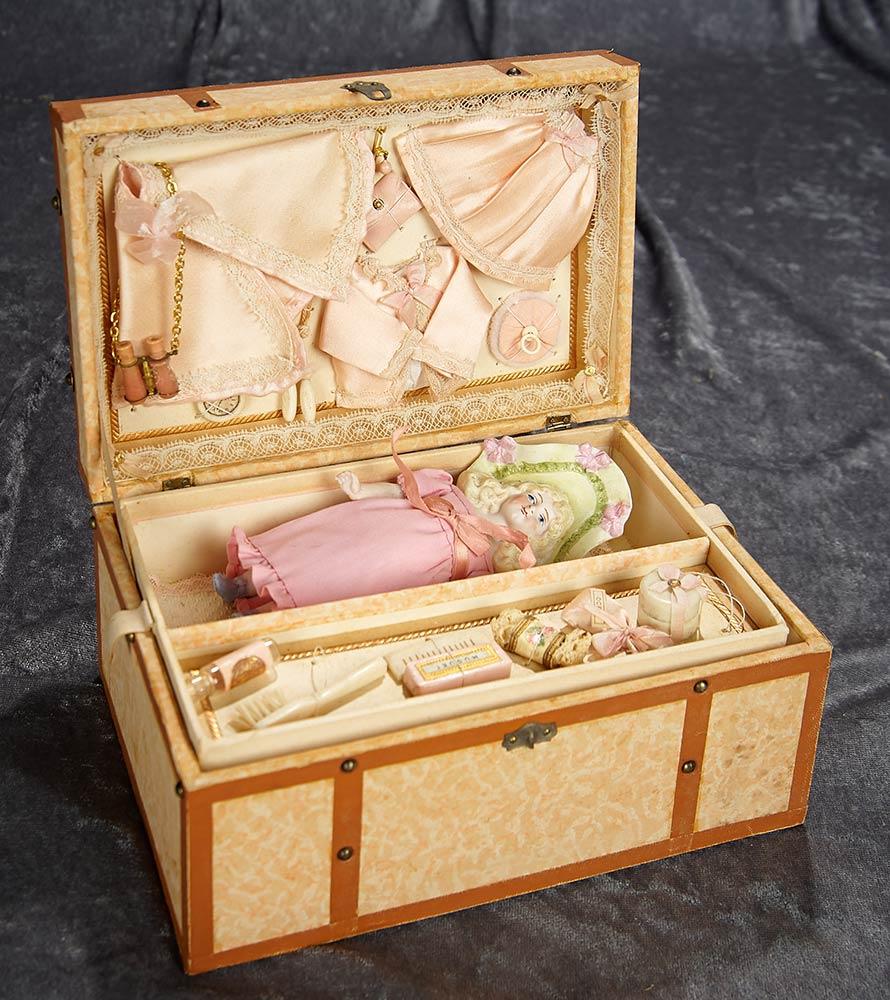 6" German bisque miniature doll with lavish sculpted bonnet in trunk with trousseau. $400/500