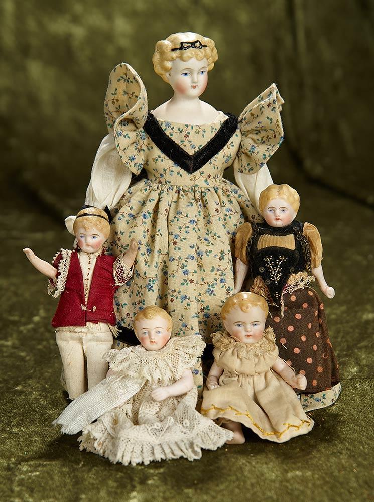 Family of miniature German bisque dolls with sculpted hair and antique costumes. $800/1200