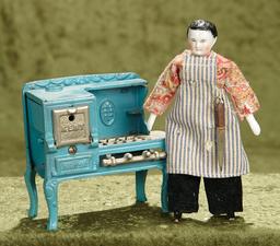 4 1/2"h. American cast iron gas stove by Kent, and German porcelain doll as chef. $400/500