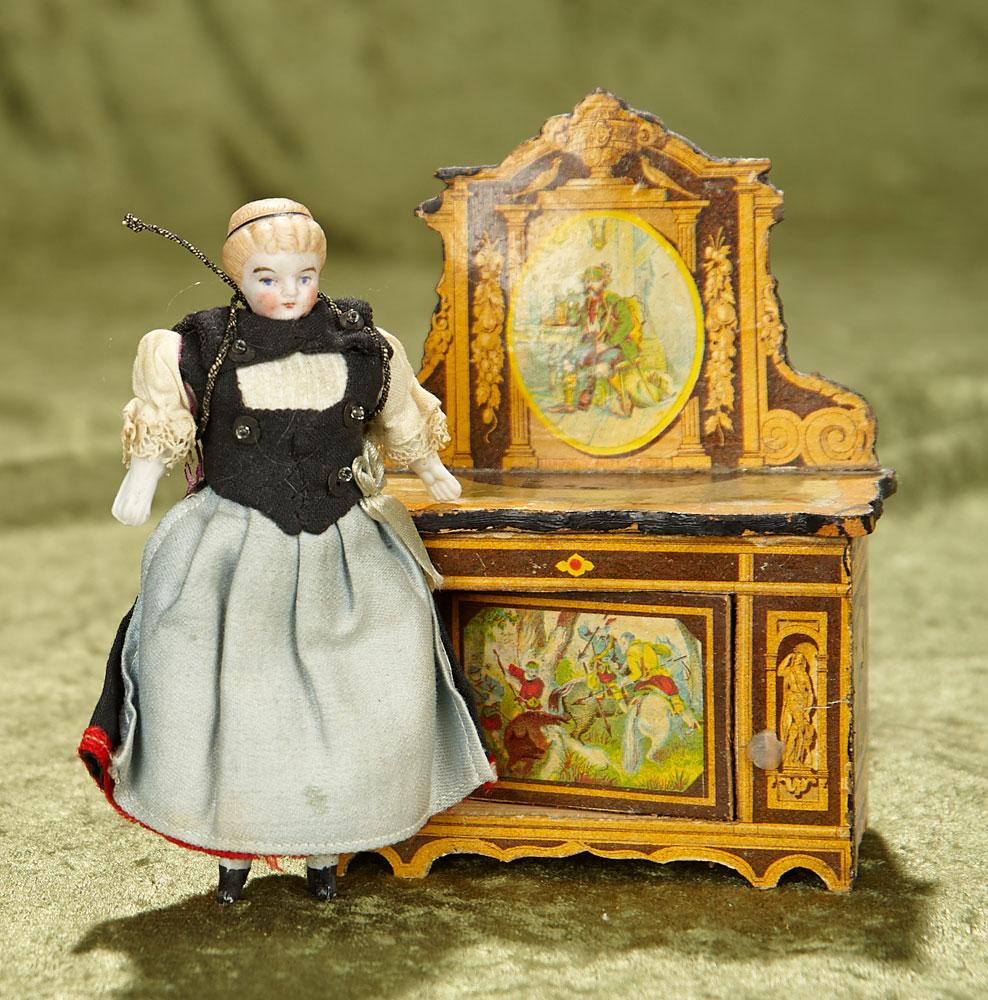 4 1/2" German bisque dollhouse doll and wooden chest with paper lithographed scenes. $300/400