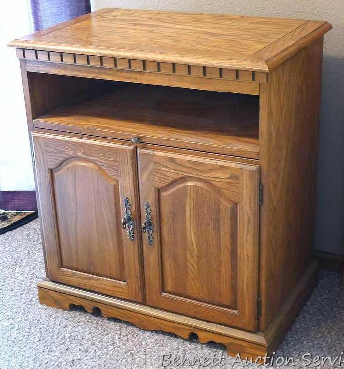 Swiveling TV stand is approx. 28" wide x 17" deep x 31" tall. Has a slide out shelf and storage