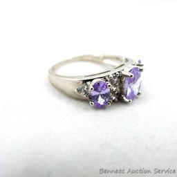 Two rings. Seller's description states 'white sapphire band/ring, size 9; purple amethyst ring, size