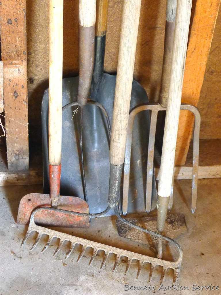 Assortment of hand tools including hoe, rake, scraper, hay fork, flat bottom shovel, and pitch fork.