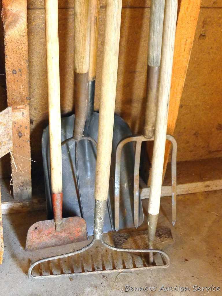 Assortment of hand tools including hoe, rake, scraper, hay fork, flat bottom shovel, and pitch fork.