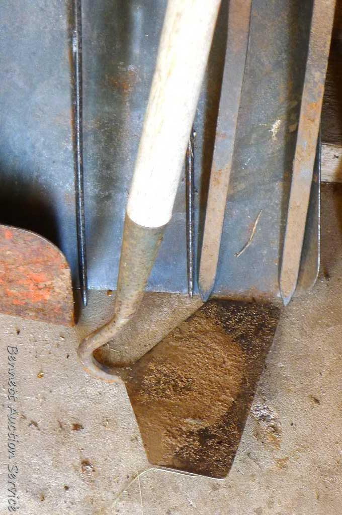 Assortment of hand tools including hoe, rake, scraper, hay fork, flat bottom shovel, and pitch fork.