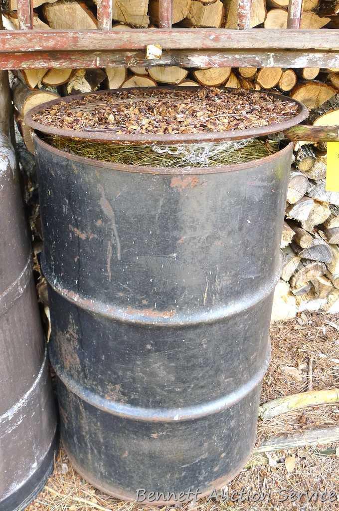 One metal and two plastic 55 gallon barrels. Metal barrel has a removable lid and looks to be filled