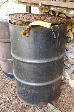 One metal and two plastic 55 gallon barrels. Metal barrel has a removable lid and looks to be filled