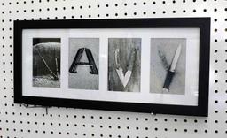 Framed "Navy" print with each letter a collage of weaponry is 21-1/2" x 9-1/2" and was donated by