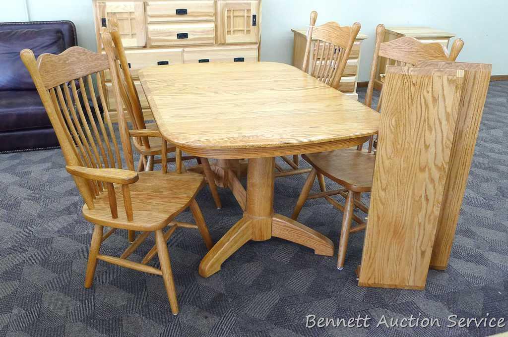 Beautiful oak dining room table with 2 captains, 2 regular chairs and 2 leaves. Appears in very