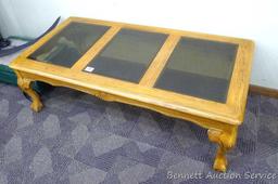 Wooden coffee table with 3 smoked colored glass panels for the table top; very sturdy; has a few
