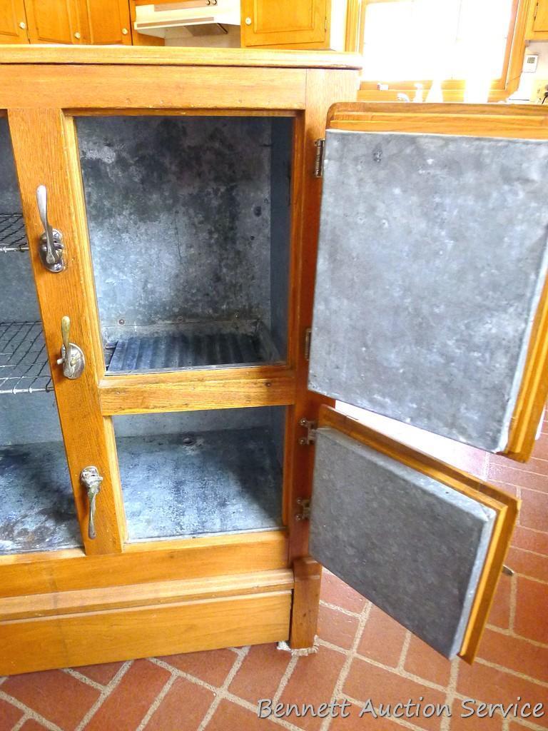 Nice smaller antique ice box has a galvanized lining, three doors with appropriate hardware and