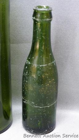 Tall green glass bottle with an interesting design stamped seal at base of bottle neck, measures 3"