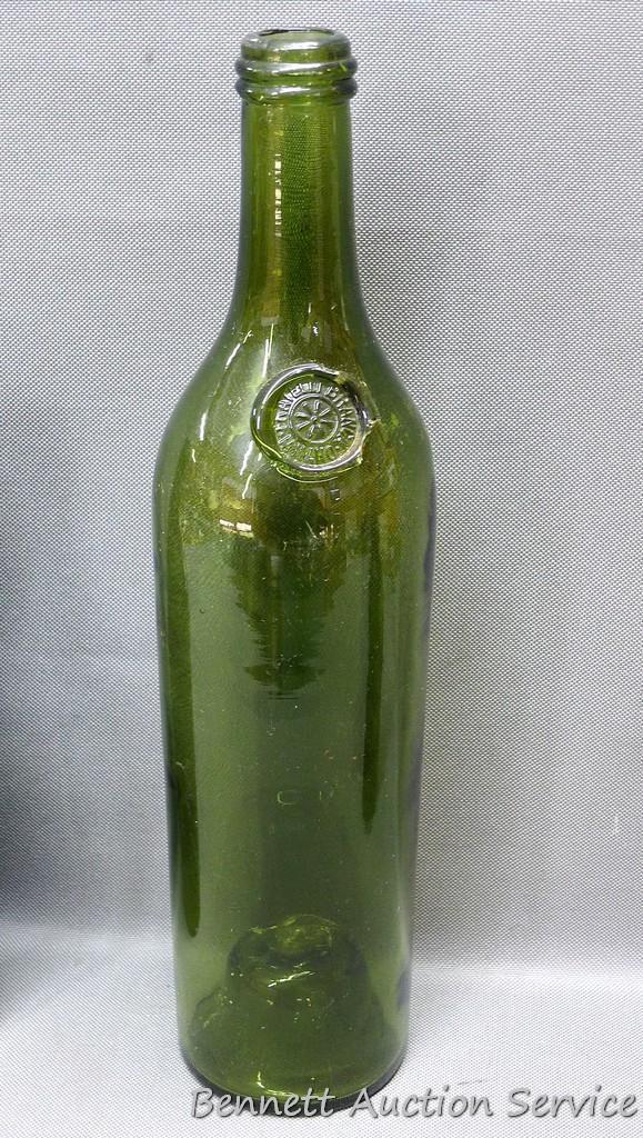 Tall green glass bottle with an interesting design stamped seal at base of bottle neck, measures 3"