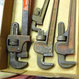 Several pipe wrenches, including 18", 14" and 7". Jaws show some wear.
