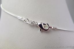 Seller's note states "2 CT Sterling silver ruby and white topaz pendant and chain". Measures overall