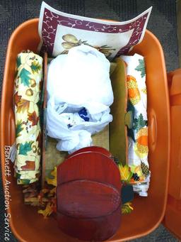 Tote with lid holds table cloths, faux leaves and pumpkin decorations. Tote is about 15" tall.