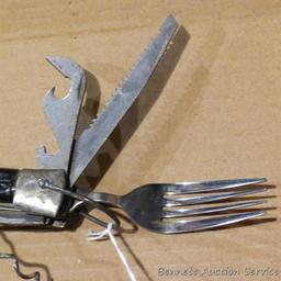 Really cool camp knife includes fork, spoon, corkscrew, knife, scissors, more. Roughly 4-3/4" x 2" x