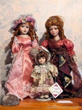 Three decorative porcelain dolls with stands, tallest is 17".