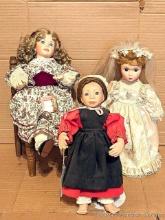 Three decorative porcelain dolls with stands, tallest is 14", comes with wooden chair for display.