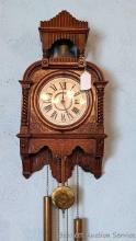 Charming antique wall clock with pendulum and weights. Runs and chimes on the hour. Measures about
