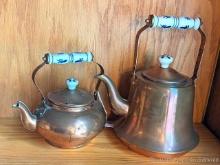 Set of 2 copper colored tea or hot water kettles. Taller measures approx 10" over handle.