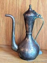 10" copper colored tea pitcher with hinged cover. Dent in kettle body and some patina but otherwise