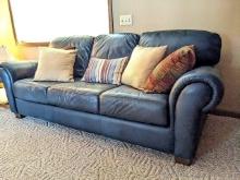 Natuzzi blue-green leather couch approx. 7" long, 3' deep from very back, with 5 throw pillows.