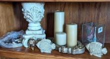 Candle holders and other decorations including polished rocks, fish, decorative blown egg with