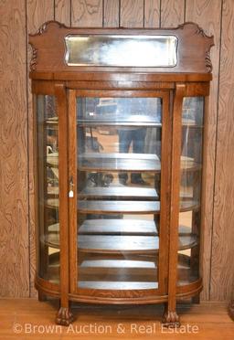 Oak china cabinet with curved glass sides, decorated backsplash with beveled mirror, paw feet,