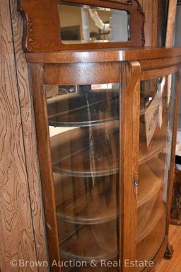 Oak china cabinet with curved glass sides, decorated backsplash with beveled mirror, paw feet,