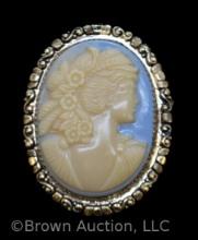 Vintage lady cameo brooch on blue background, gold frame
