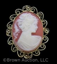 Vintage lady cameo brooch on peach background, nice gold filigree frame