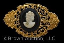 Vintage lady cameo brooch on black background, gold filigree frame