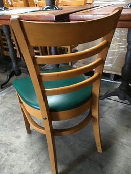 Dining chairs with green padded seats