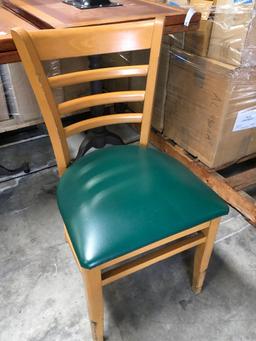 Dining chairs with green padded seats