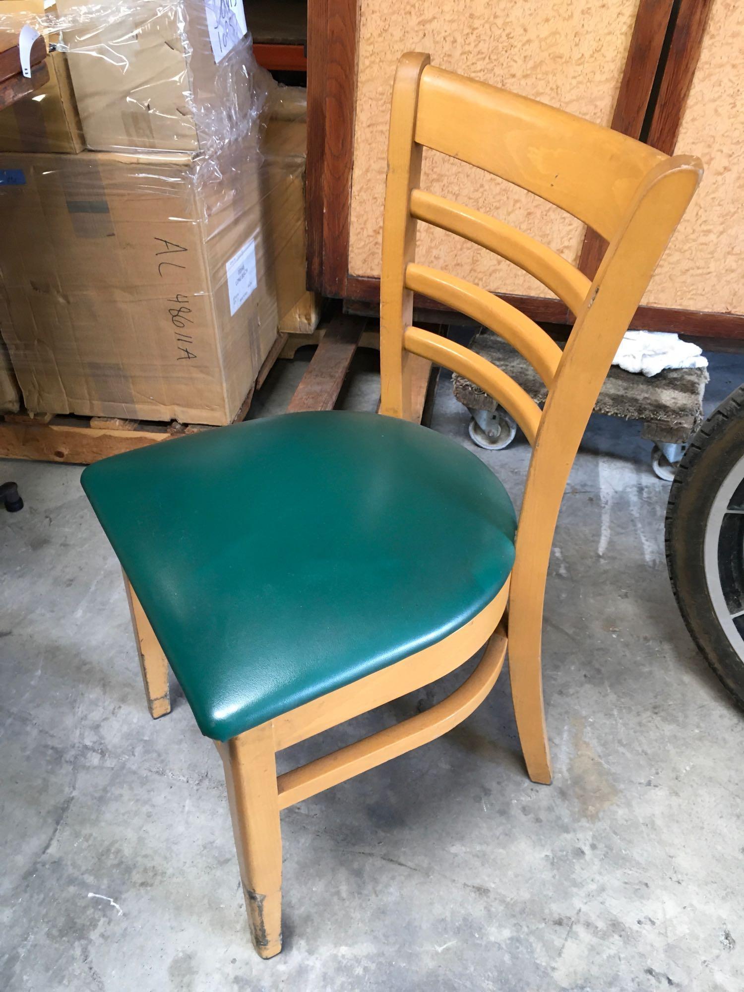 Dining chairs with green padded seats