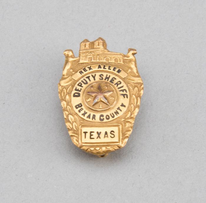 Gold Shield Badge, marked Rex Allen, Deputy Sheriff Bexar County, 1 1/4" tall.  Badge will be accomp