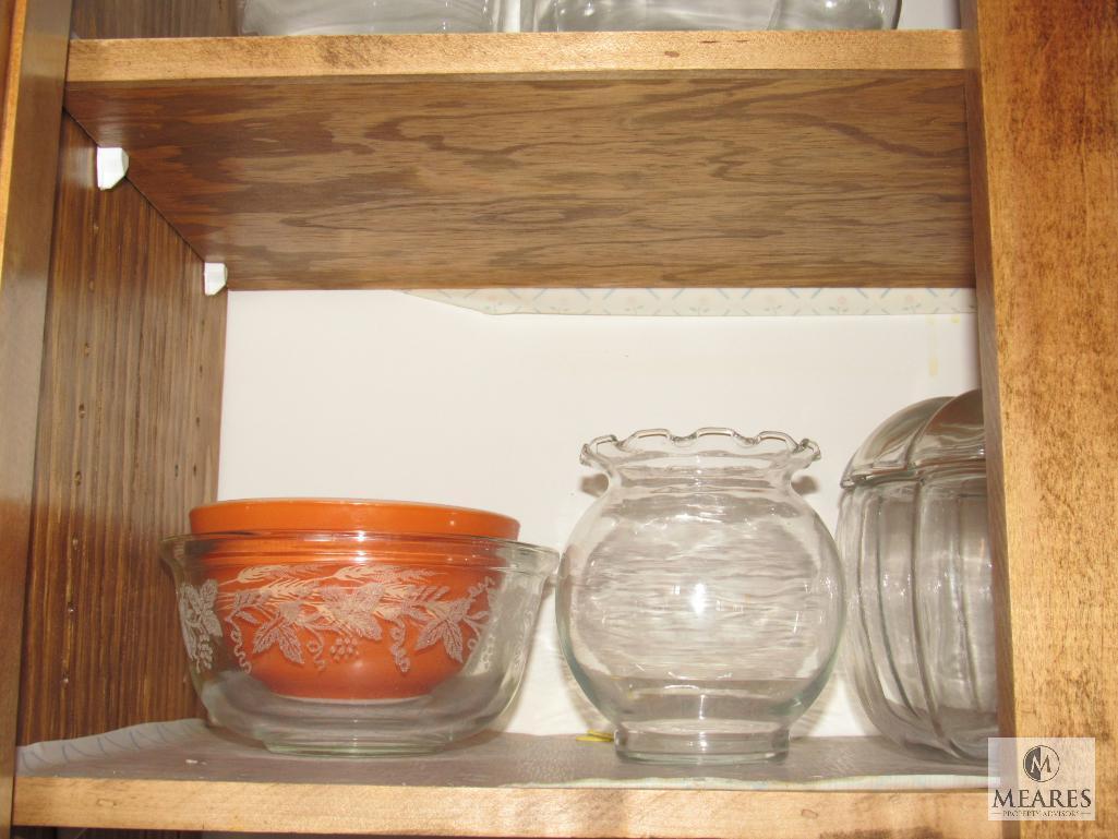 Contents of kitchen cabinet includes glass bowls canister bowls and plates